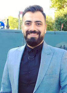Men smiling at Kobani Festival, celebrating Kurdish culture and community engagement.